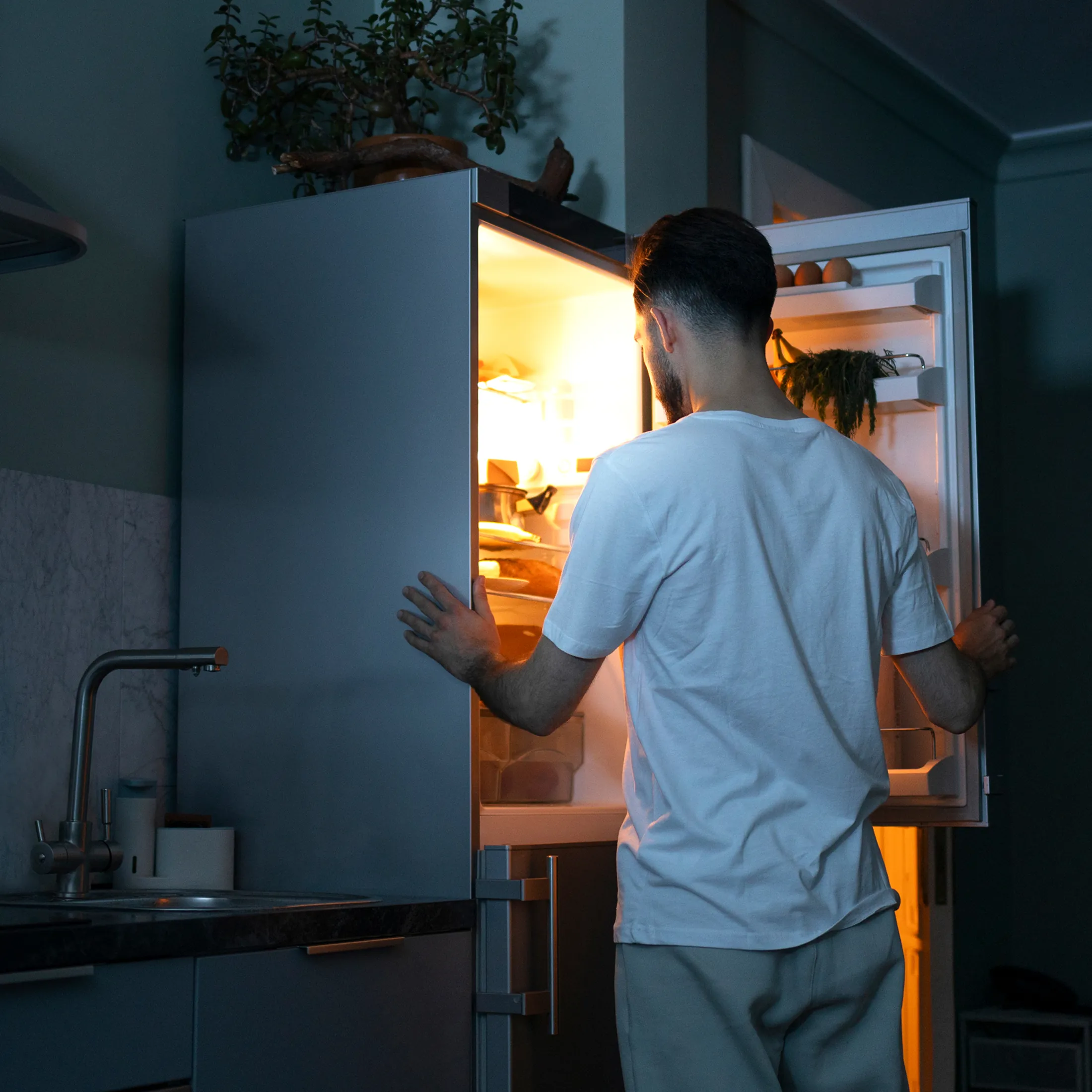 Homme devant son frigo ouvert